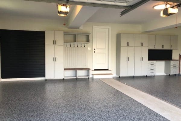 Organized-space inspiration: a garage with tall cabinets, a bench, hooks and a slatwall