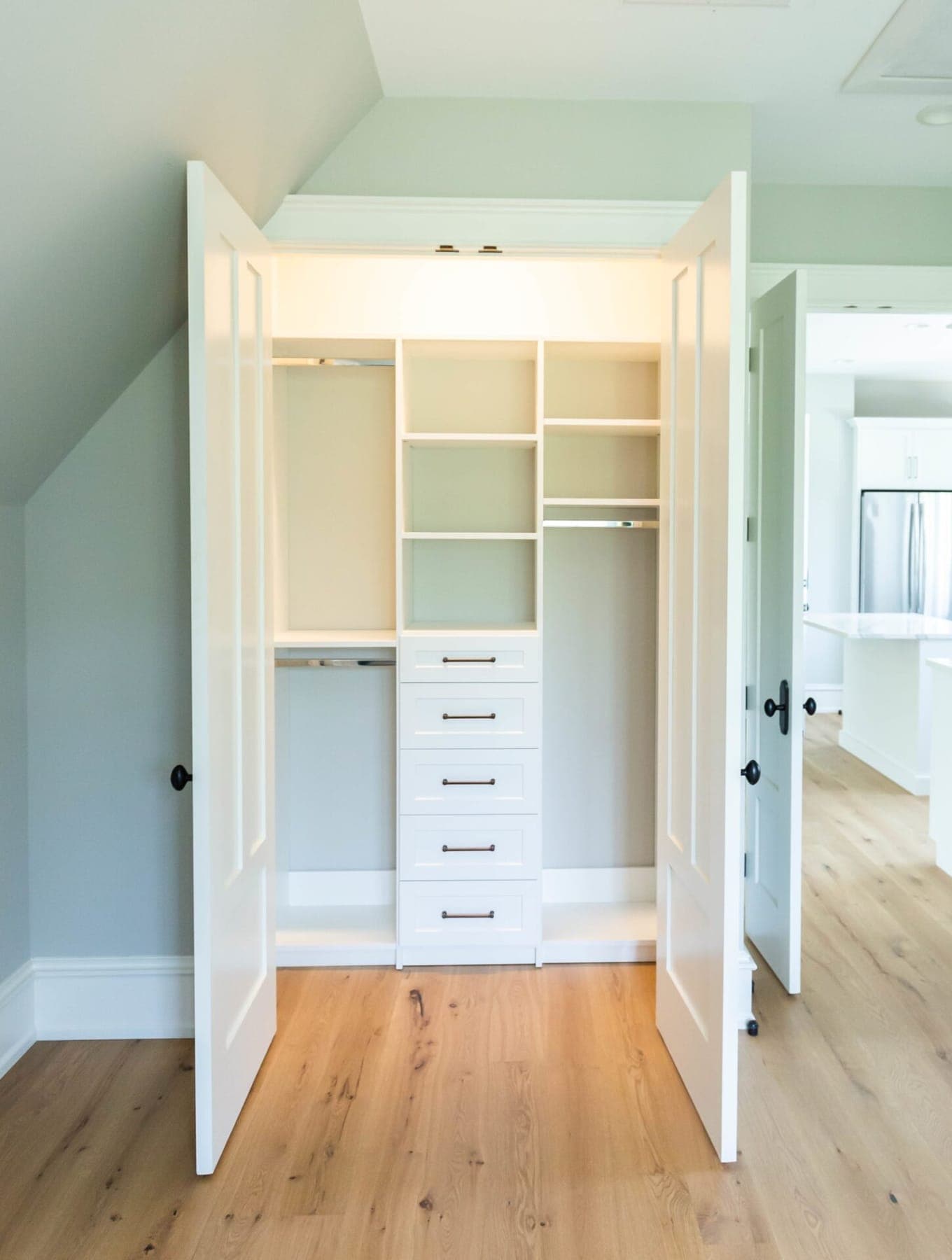 Organized-space inspiration: a reach-in closet with double hanging, adjustable shelves and a drawer stack