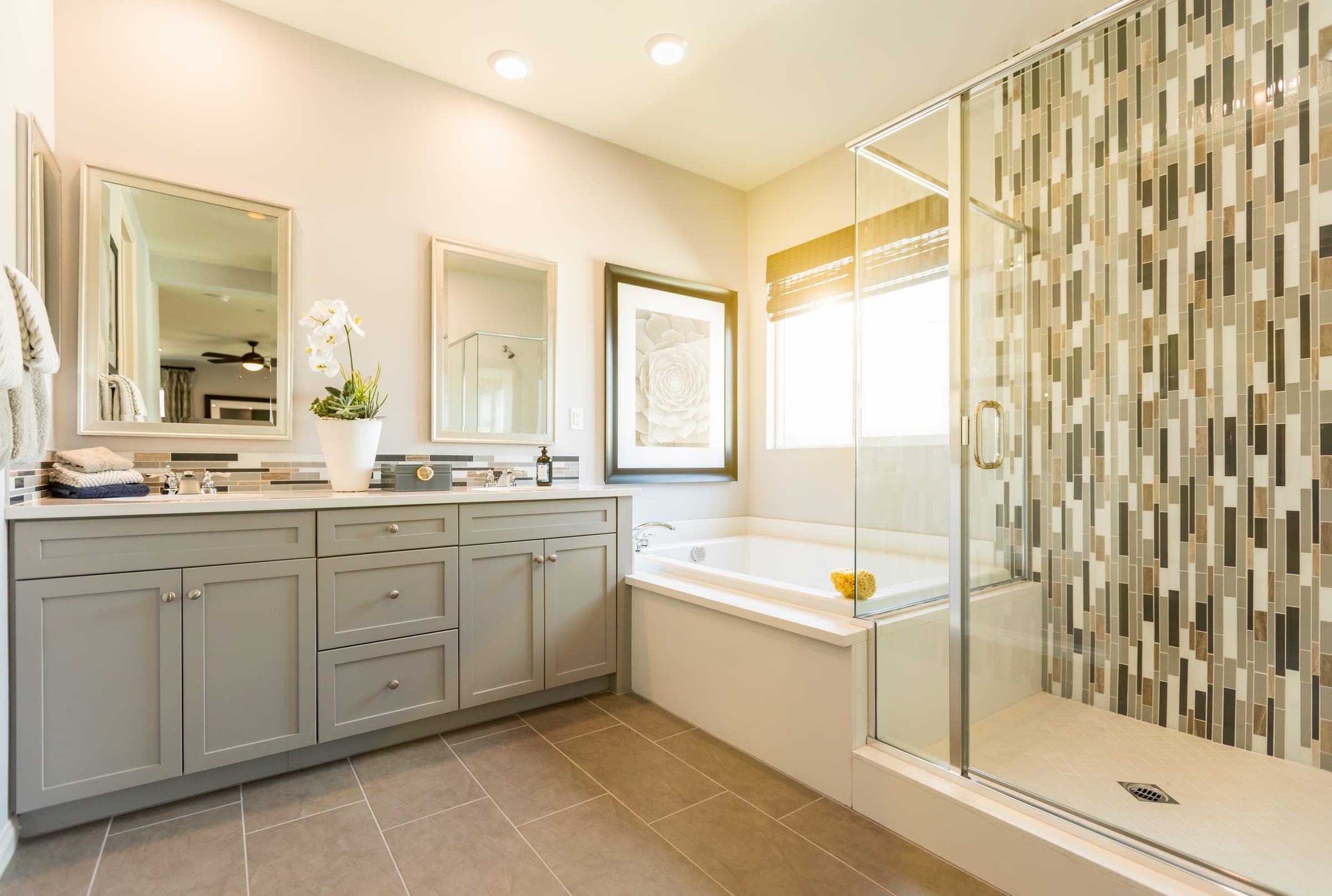 Cali Craft bathroom renovation with a vanity, a built-in tub and a glass shower enclosure with mosaic tile
