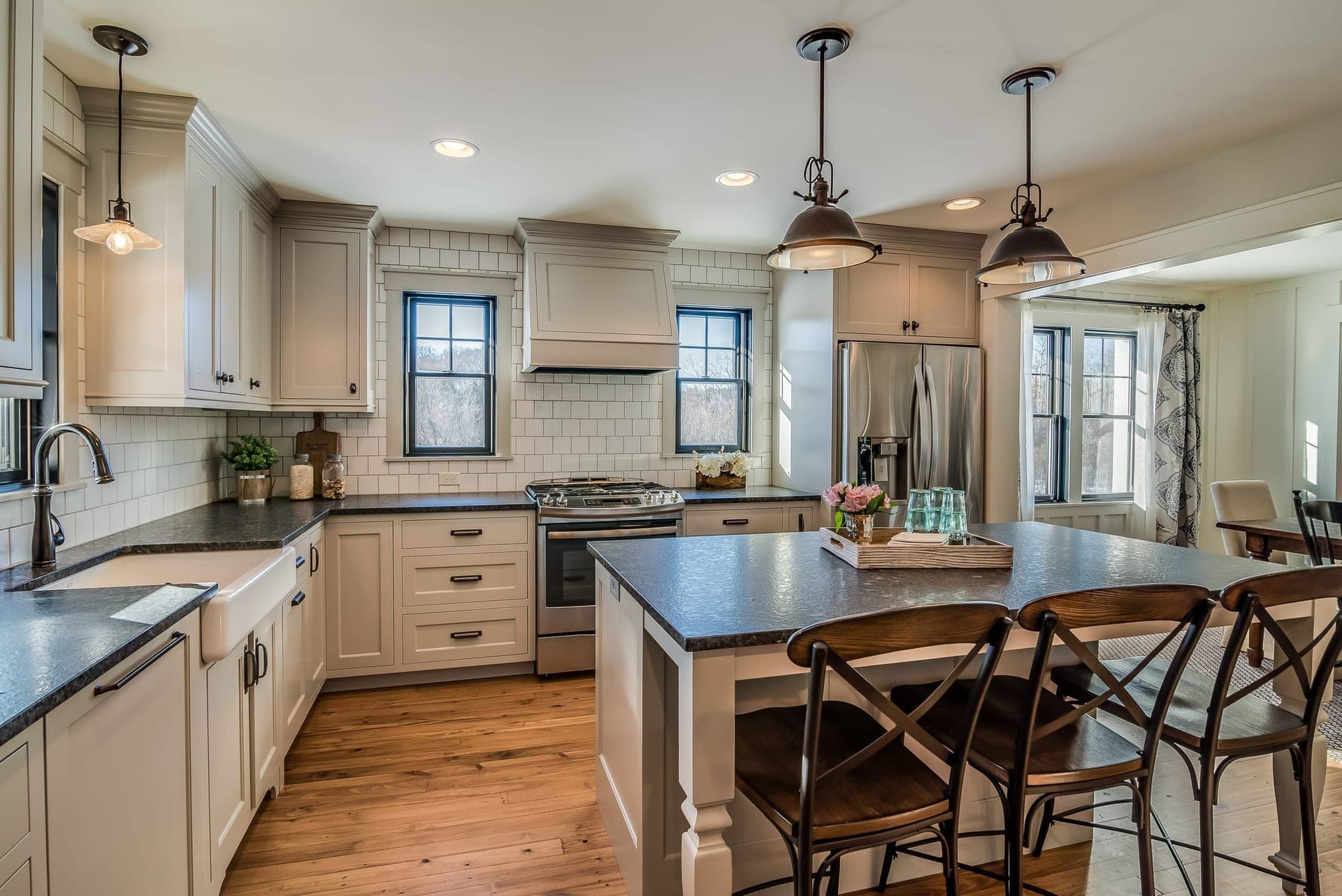 Cali Craft kitchen renovation with cream cabinetry, a timber island with seating and subway tile backsplash