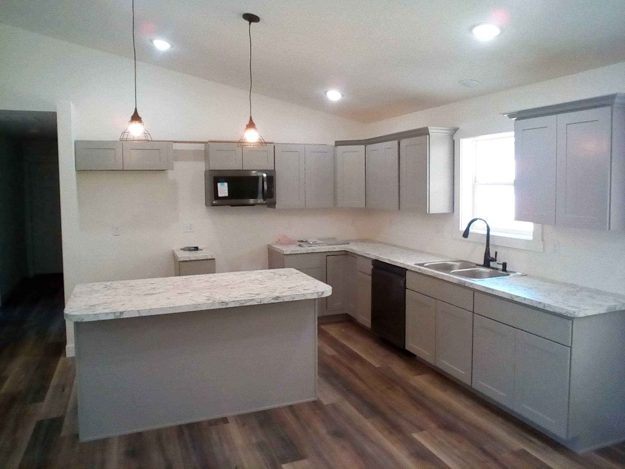 Cali Craft kitchen renovation with grey cabinetry, a stone countertop and wood-look flooring