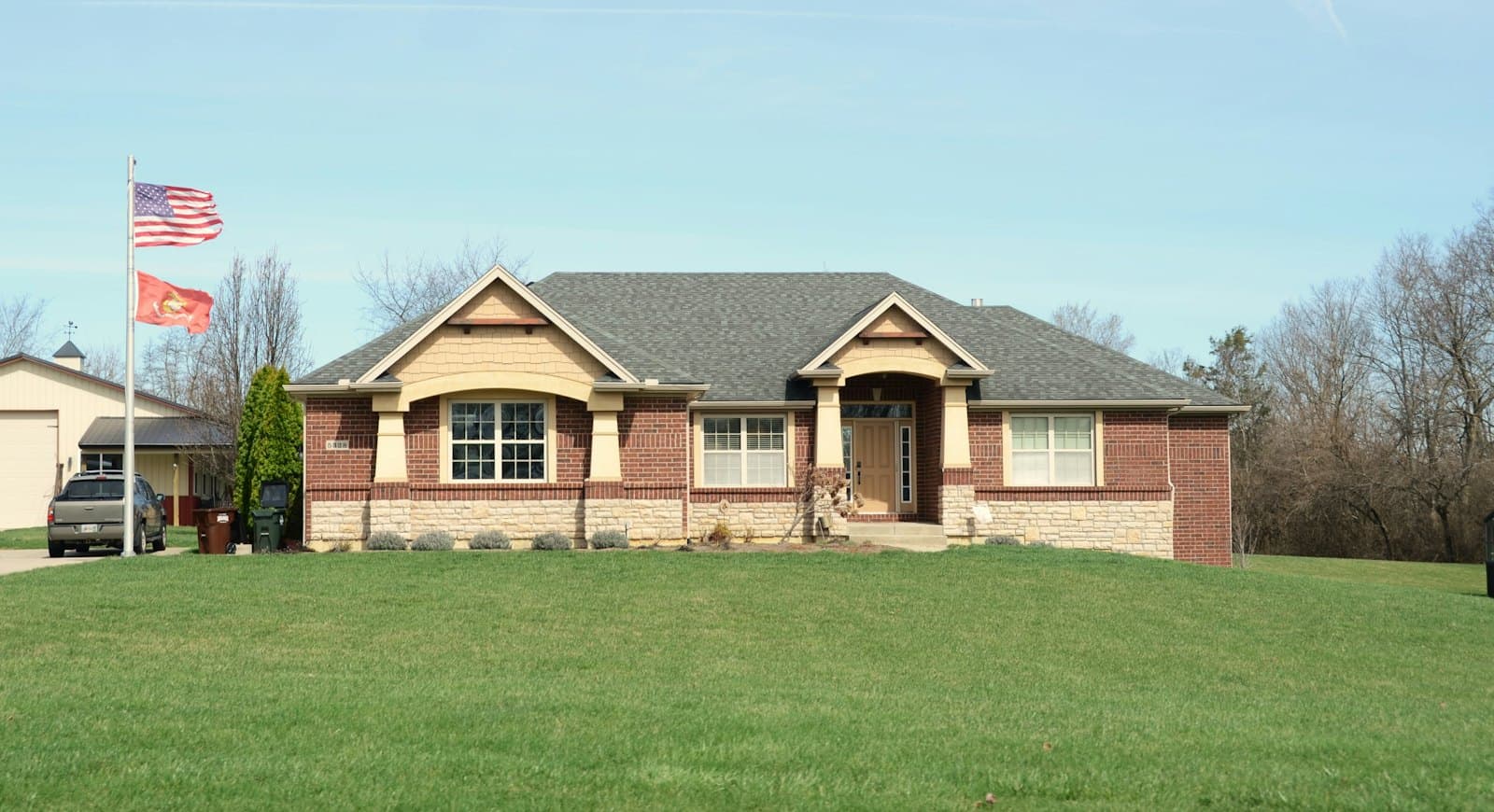 Stock concept image of a single-storey brick home with a gabled entry and a wide lawn — not an actual Cali Craft Renovations project
