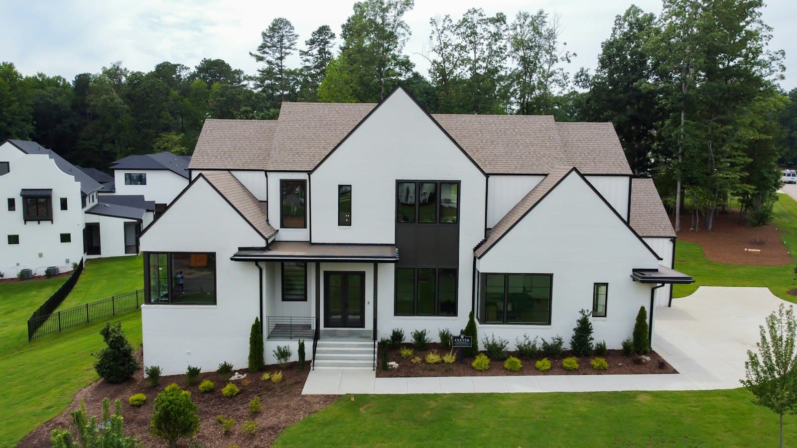 Stock concept image of a newly built white two-storey home with dark window trim and fresh landscaping — not an actual Cali Craft Renovations project