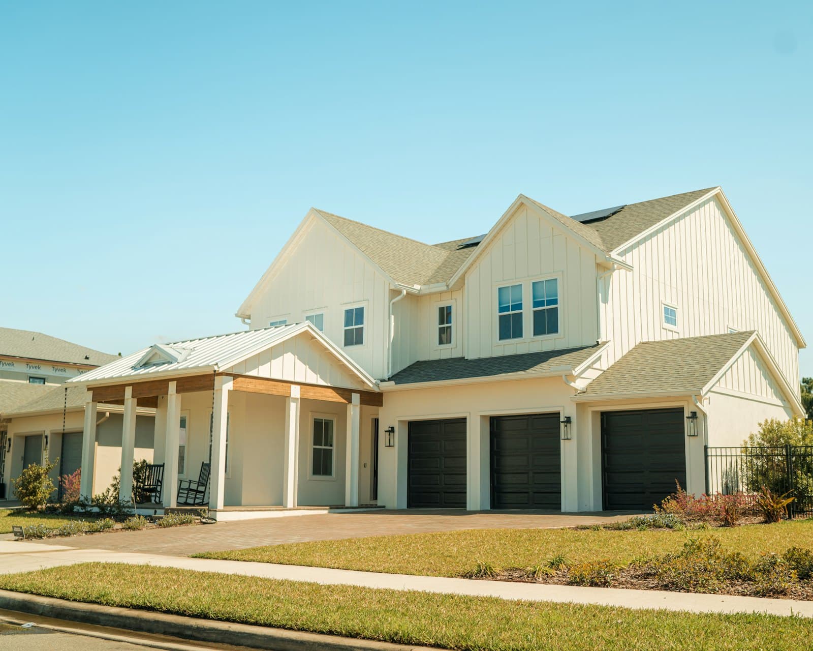 Stock concept image of a large two-storey home with a covered porch and a three-car garage — not an actual Cali Craft Renovations project